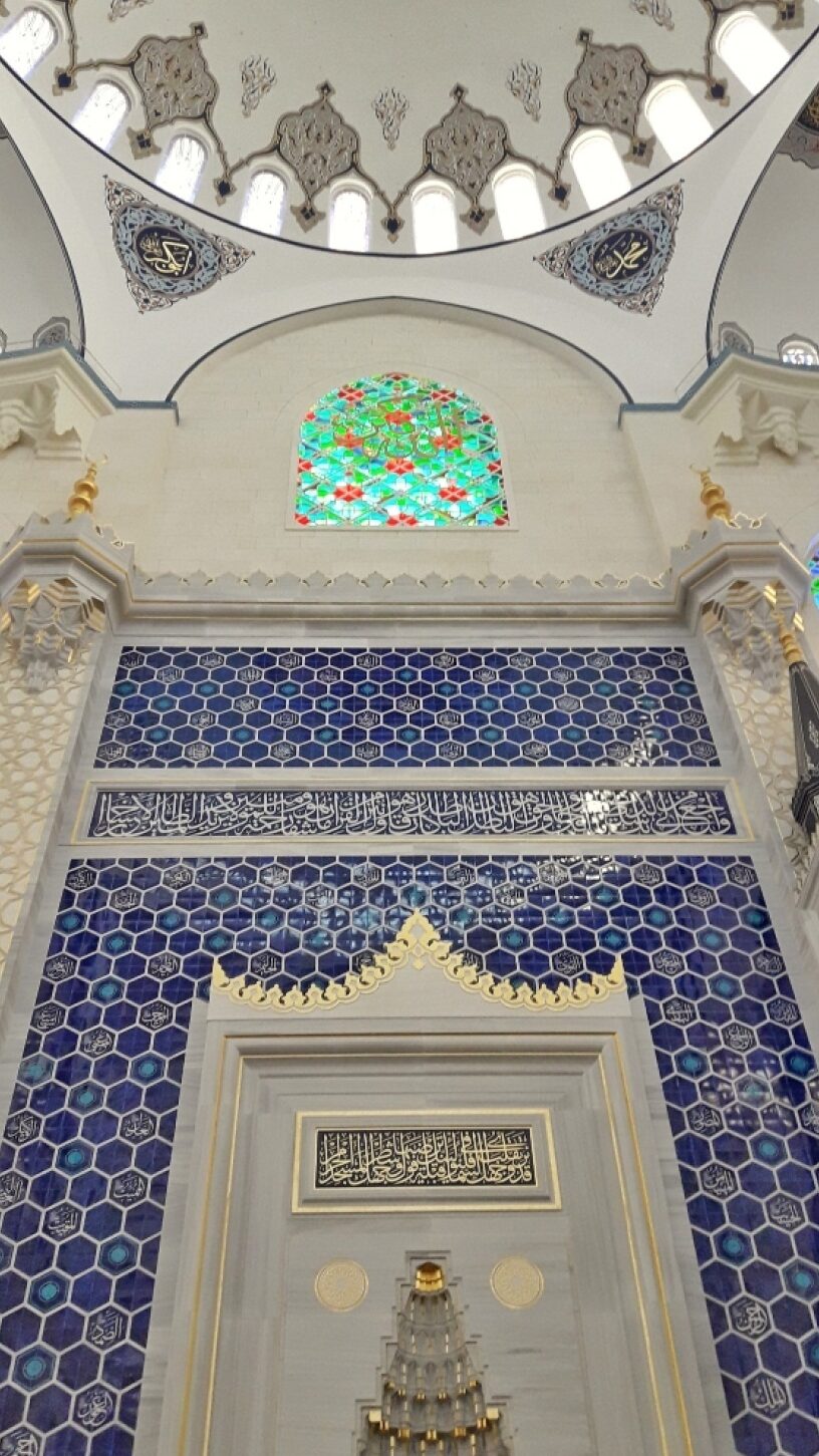 فضای داخلی مسجد جامع چاملیجا با کاشی کاری آبی و پنجره رنگی