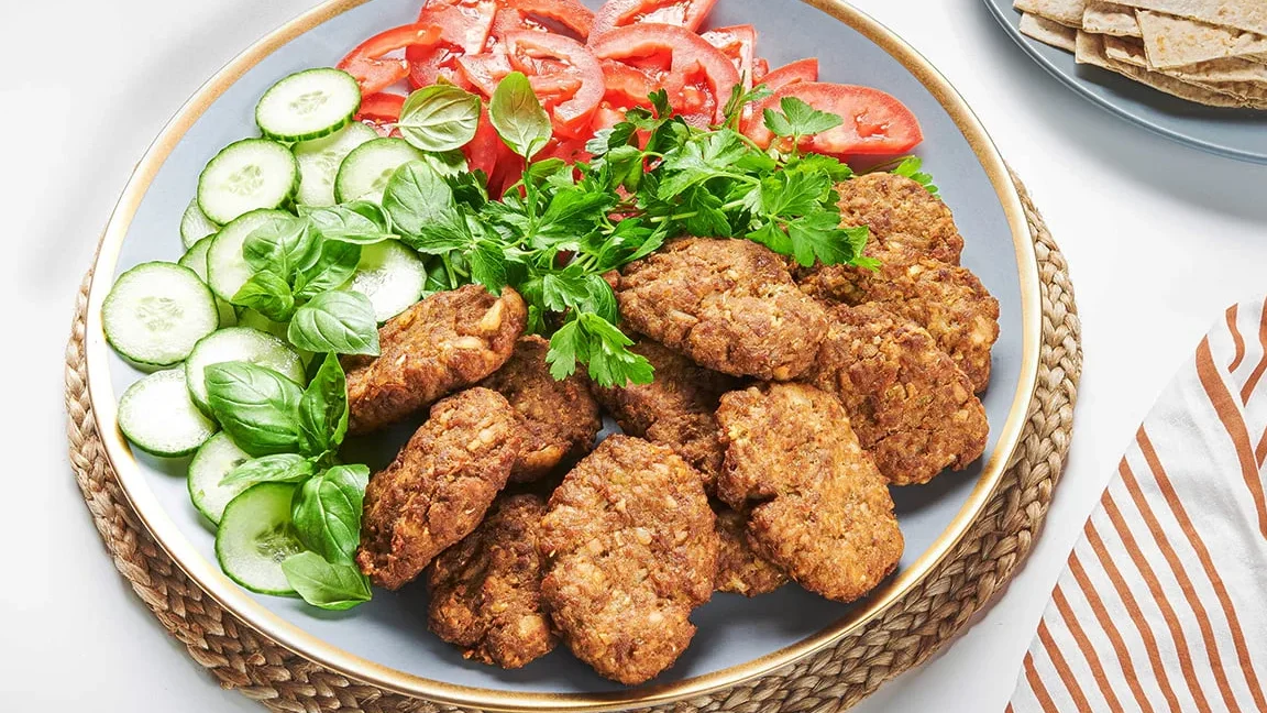 طرز تهیه کتلت گوشت و سیب زمینی؛ آموزش کتلت رستورانی طرز تهیه کتلت رستورانی با گوشت چرخ کرده - کتلت های گوشت سرخ شده کنار خیار و گوجه