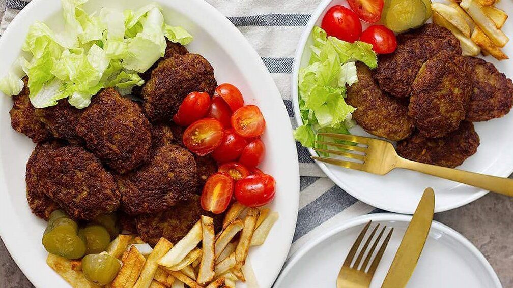 دو بشقاب کتلت سرخ شده کنار سیب زمینی و سبزی، طرز تهیه کتلت
